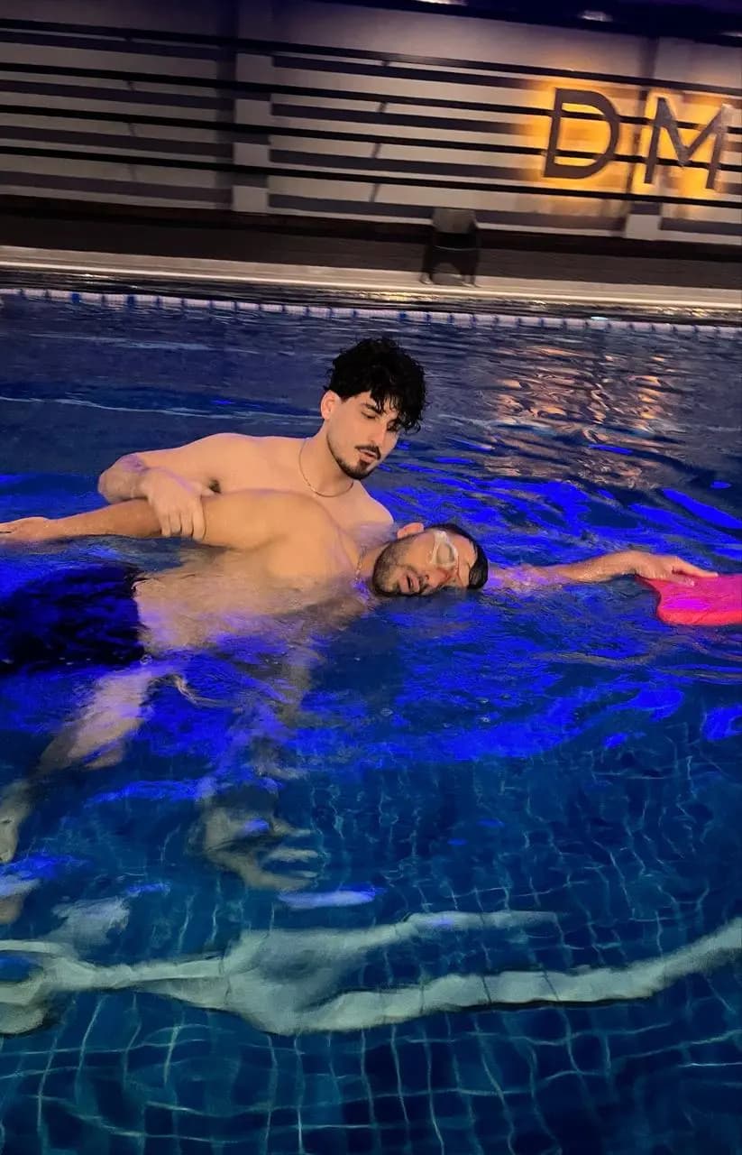 کودک با حمایت مربی، صورت در آب و در حال تمرین بازدم منظم